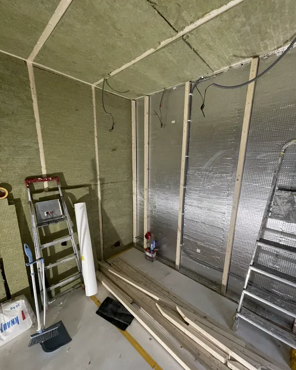 Framed walls with insulation and an isolation layer going in